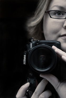 Photograph of photographer Janelle Lorenzen holding a Nikon D200 DSLR camera